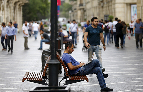A man uses his laptop in a Baku street. Azerbaijan has extended its press freedom crackdown to include bloggers and social media users. (Reuters/Stoyan Nenov)