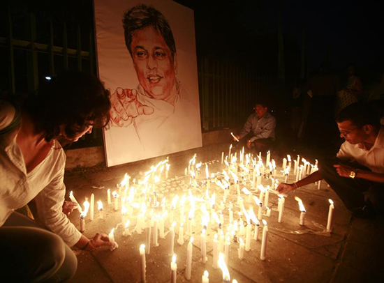 Media rights activists light candles in front of the portrait of slain Sri Lankan newspaper editor Lasantha Wickramatunga during a silent vigil to condemn his killing in Colombo, January 15, 2009. (Reuters/Buddhika Weerasinghe)