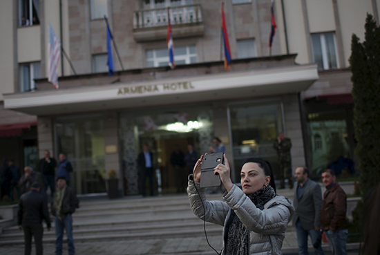 A woman takes a photograph in Stepanakert, Nagorno-Karabakh, April 7, 2016. (Reuters)