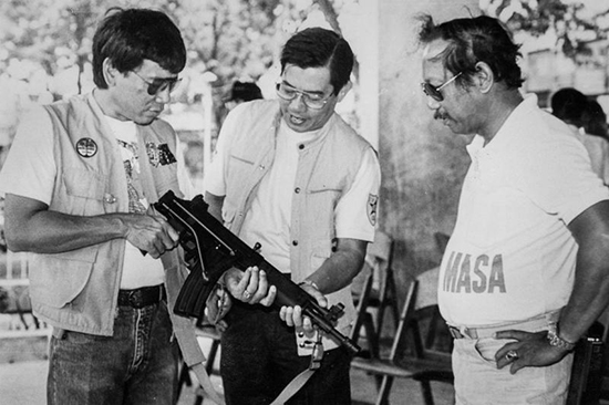 Philippine President Rodrigo Duterte (left), then mayor of Davao, inspects an assault rifle with Regional Police Chief Miguel Abaya (center) in the late 1980s. (Reuters/Renato Lumawag)