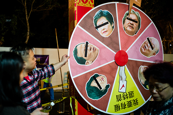 A man spins a wheel during new year festivities to predict the winner of Hong Kong's chief executive election. The daily Sing Pao says its staff are being harassed because of its critical coverage. (AFP/Anthony Wallace)