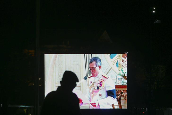 A military officer watches a television screen showing Thailand's King Maha Vajiralongkorn Bodindradebayavarangkun speaking after he accepted an invitation from parliament to succeed his late father at the Dusit Palace in Bangkok, Thailand, December 1, 2016. (Reuters/Athit Perawongmetha)