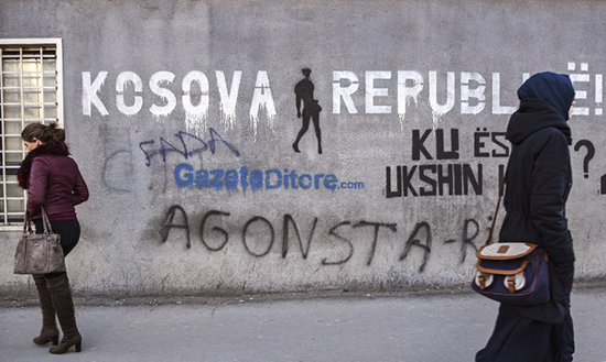 Women walk by graffiti reading Kosovo Republic in Pristina, February 13, 2017. (AFP/Armend Nimani)