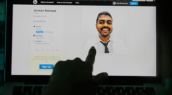 A Sri Lankan woman in Colombo points to a photo of murdered Maldivian blogger Yameen Rasheed from his blog, April 23, 2017. (AP/Eranga Jayawardena)