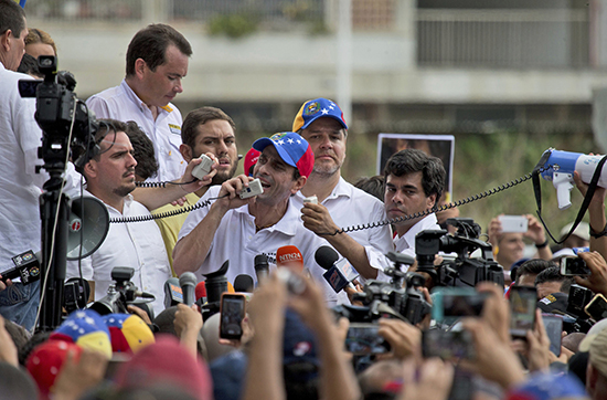 Opposition leader Henrique Capriles addresses protesters and the press in Caracas on April 22. Journalists and news outlets covering the unrest have been harassed. (AP/Fernando Llano)