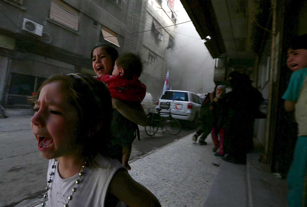 Syrian children react after what activists said was shelling by forces loyal to President Bashar Assad near the Syrian Arab Red Crescent center in Damascus on May 6, 2015. (Reuters/Bassam Khabieh)