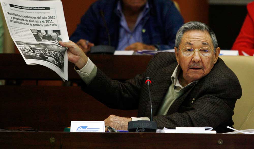 Cuban President Raúl Castro holds up a copy of the newspaper Juventud Rebelde in Havana in December 2010. Freedom of speech is still curbed despite a series of press reforms. (AP /Ismael Francisco, Prensa Latina)
