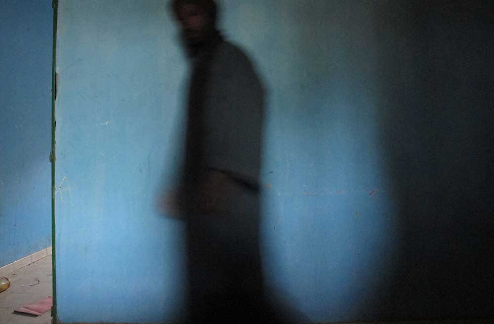 A Timbuktu resident walks past a room where he and other residents say Al-Qaeda held European hostages at Mali's Ministry of Finance regional audit department. (AP/Rukmini Callimachi)