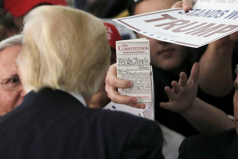 A member of the crowd holds up a copy of the U.S. Constitution at a campaign rally for Donald Trump in Rhode Island, in April 2016. (Reuters/Brian Snyder)