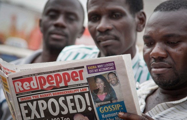 Ugandans read a copy of the newspaper Red Pepper in Kampala, in this February 25, 2014, file photo. (AP/Rebecca Vassie)