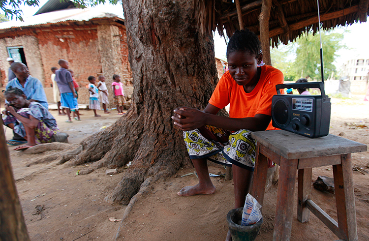 A young Kenyan listens to the news on the radio in this March 2013 file photo (Reuters/Joseph Okanga)