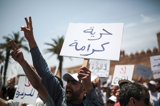 A protester in Rabat holds a sign saying "Freedom and Dignity," June 11, 2017. (AP/Mosa'ab Elshamy)