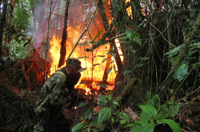 A soldier destroys chemicals used in the production of cocaine in Ragondalia, in the remote Colombian state of Norte de Santander, November 22, 2006. Dutch journalists Derk Johannes Bolt and Eugenio Ernest Marie Follender were abducted in the state, police said yesterday.