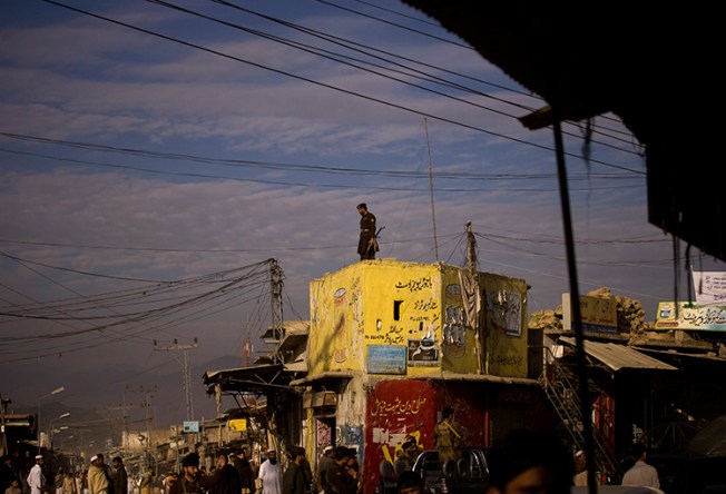 In this November 29, 2008, file photo, a member of the Frontier Corps paramilitary group surveys a street in Khar, Pakistan. (AP/Emilio Morenatti)