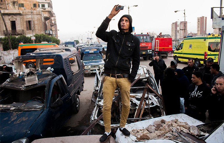 An Egyptian uses his phone to record the aftermath of a deadly explosion outside a police headquarters in December 2013. Journalists who use smartphones and messaging apps in their reporting say they are wary of surveillance and trolling under Egypt's press crackdown continues. (AP/Ahmed Ashraf)