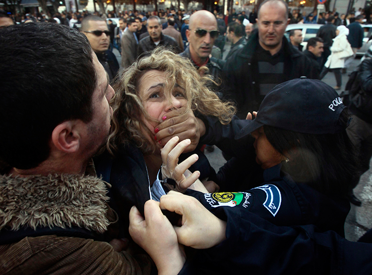 In this file photograph, police detain a protester during a March 6, 2014, demonstration in Algiers against Algerian President Abdulaziz Bouteflika's decision to run for a fourth term. (Reuters/Ramzi Boudina)
