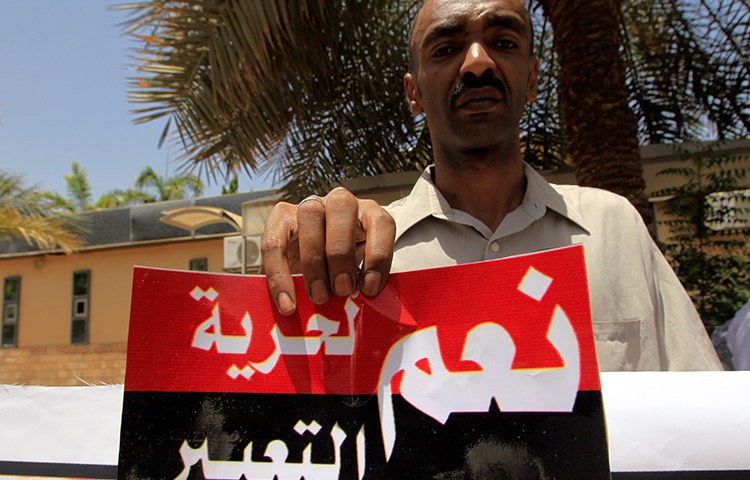 A Sudanese journalist in Khartoum holds a sign reading "Yes to freedom of expression" in this file photo from June 2012. (Reuters/Mohamed Nureldin Abdallah)