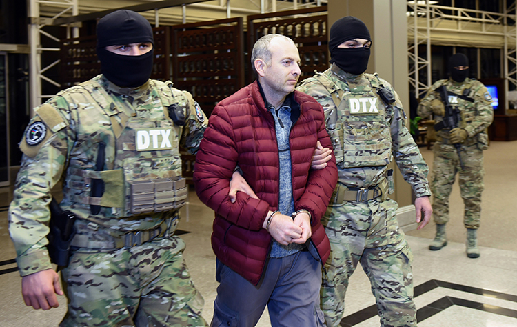 Aleksandr Lapshin is escorted through Baku airport in February after being extradited from Belarus. An Azerbaijan court has jailed the blogger for three years. (AFP/Tofik Babayev)