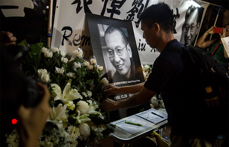 Supporters pay their respects to Chinese Noble laureate Liu Xiaobo at a vigil outside the Chinese Liaison Office of Hong Kong. The jailed activist and journalist died in July. (AFP/Isaac Lawrence)