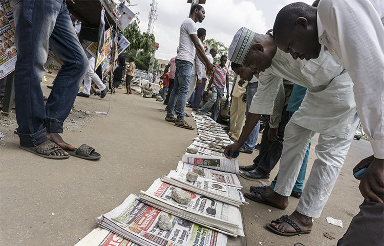 Newspapers are sold on the street in Abuja, Nigeria, in May. Nigerian police raided the offices of one of the country's daily newspapers in June over a long-standing legal dispute. (AFP/Stefan Heunis)