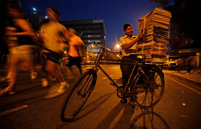 A newspaper vendor stacks newspapers on his bicycle in Mumbai. Indian journalists say companies are using the legal notices as an attempt to silence critical reporting. (AP/Rajesh Kumar Singh)