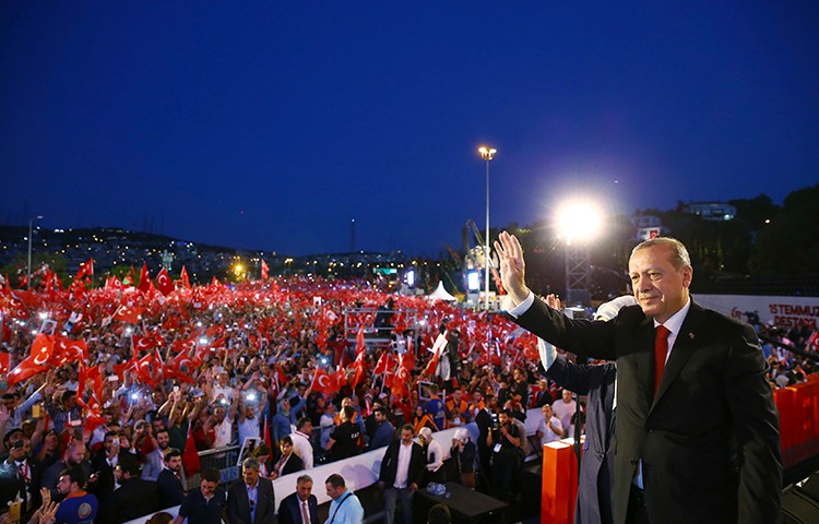President Erdogan waves to supporters during an event in Istanbul to mark the one-year anniversary of Turkey's failed coup attempt. A news editor was detained on July 15 over a column on the government's response to the failed coup. (Presidency Press Service via AP/Pool)