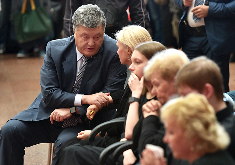 President Petro Poroshenko talks with relatives during a memorial in Kiev for Pavel Sheremet. The president promised a swift investigation, but to date no suspects have been identified. (AFP/Sergei Supinsky)