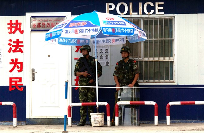 Chinese paramilitary policemen guard a checkpoint in China's Xinjiang province. Authorities briefly detained a Canadian journalist in the region who was interviewing residents about the Uighurs' security situation. (AP/Ng Han Guan, File)