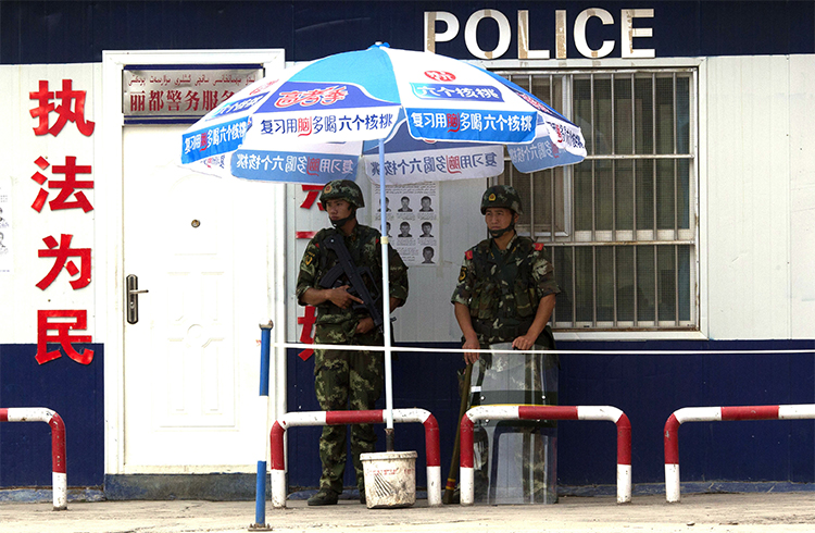 Chinese paramilitary policemen guard a checkpoint in China's Xinjiang province. Authorities briefly detained a Canadian journalist in the region who was interviewing residents about the Uighurs' security situation. (AP/Ng Han Guan, File)