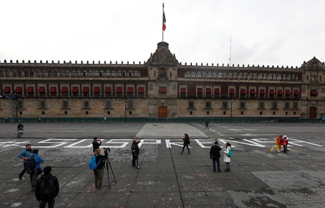 An activist puts on a window pictures of journalists who have been killed in Mexico during a demonstration against the murder of journalists in Mexico, outside the building of Attention to Crimes against Freedom of Expression (FEADLE) in Mexico City, Mexico on June 15, 2017. (Reuters/Edgard Garrido)