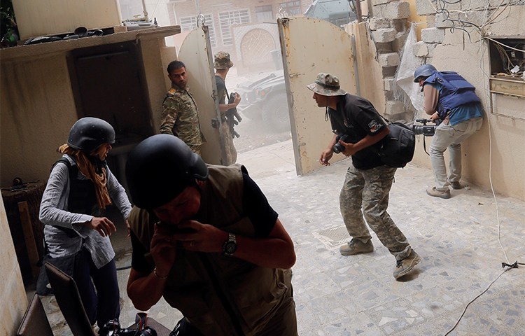 Photographers take cover during clashes between Iraqi forces and Islamic State militants in Mosul in May 2017. Journalists covering the fighting are advised to take safety precautions. (Reuters/Danish Siddiqui)