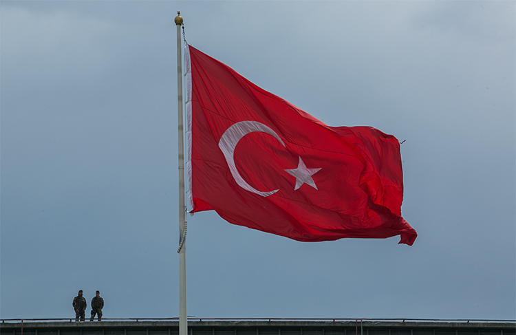 Soldiers stand near a Turkish flag in Istanbul in May 2017. Photojournalist Çağdaş Erdoğan is charged with terrorism for taking a photo of a National Intelligence Building. (AFP/Gurcan Ozturk)