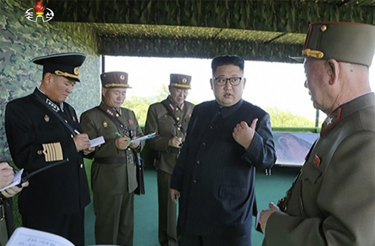 In this image from a video aired by North Korea's KRT in August, Kim Jong Un speaks with officials in North Korea. The country has sentenced two South Korean journalists to death in absentia. (KRT via AP Video)