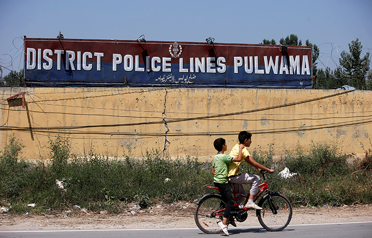 Boys ride past a police camp in the Pulwama district of the Jammu and Kashmir state. Photojournalist Kamran Yousuf, who frequently worked in this region, was arrested on accusations of stone throwing. (Reuters/Danish Ismail)