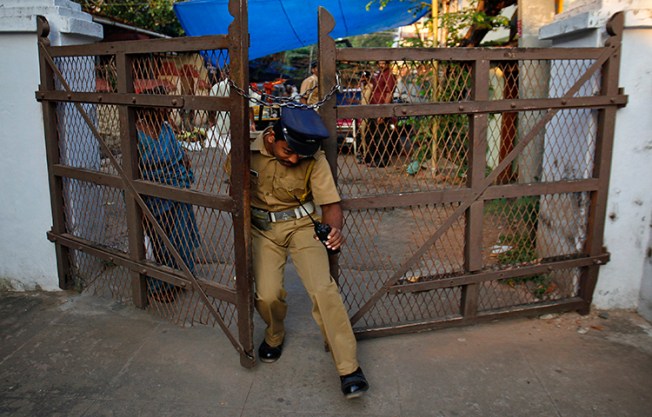 A policeman tries to enter through one of the gates in Sree Padmanabhaswamy temple complex in Thiruvananthapuram, capital of the southern Indian state of Kerala, February 20, 2012. A local newspaper filed a complaint with the Thiruvananthapuram rural district police after policeman allegedly attacked one of its journalists. (Reuters/Danish Siddiqui)