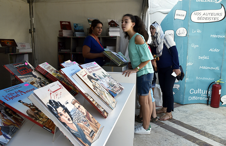 Women browse graphic novels at a comic festival in Algiers in October 2017. The co-founder of an Algerian news outlet says access to his news website is blocked. (AFP/Ryad Kramdi)