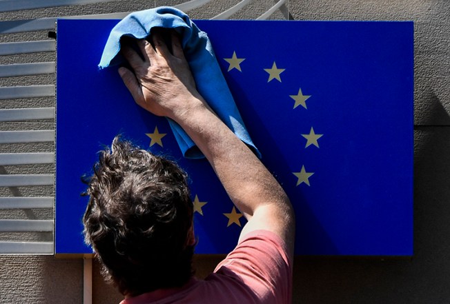 A worker cleans a EU flag in Berlin on May 19, 2017. The EU parliament is due to vote on October 12 on a proposed review mechanism of surveillance tool exports. (AFP/John MacDougall)