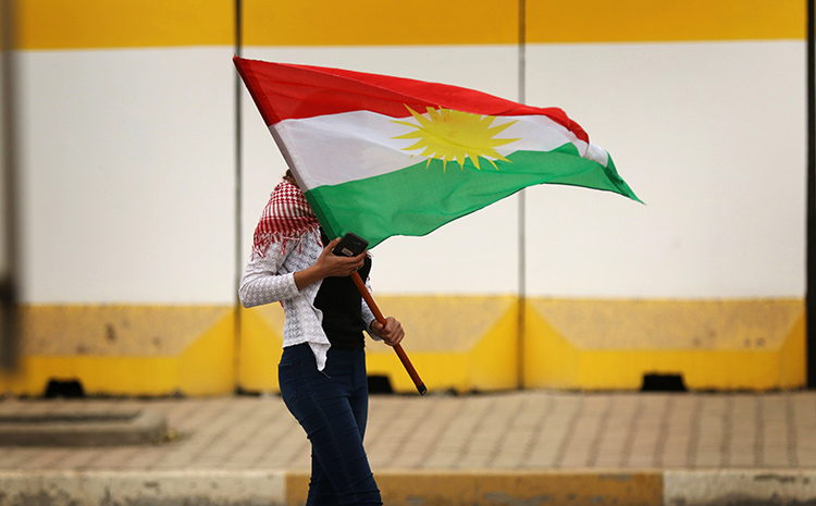 A Kurdish flag is waved during a rally in support of the Iraqi Kurdish leader in Erbil on October 30, 2017. Amid unrest in the region, Kurdish news outlets are attacked and harassed. (AFP/Safin Hamed)