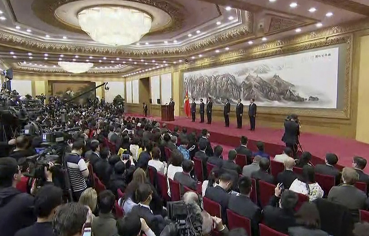 In this image made from video, Chinese President Xi Jinping, seventh from right on stage, introduces new members of the Politburo Standing Committee to the media at Beijing's Great Hall of the People on October 25, 2017. (APTN via AP)