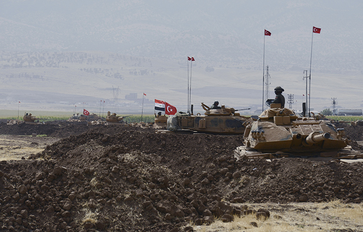 Turkish and Iraqi soldiers sit on Turkish tanks during exercises in Silopi, southeastern Turkey, near the border with Iraq, on September 26, 2017. A Wall Street Journal reporter is convicted of terrorism charges for her reporting from the area.(DHA-Depo Photos via AP )