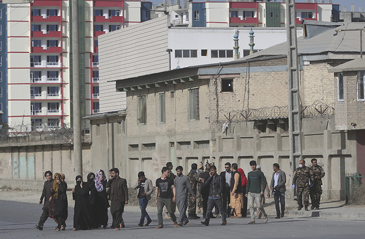 Security personnel evacuate employees of the Shamshad TV building after an attack in Kabul, Afghanistan, Tuesday, Nov. 7, 2017. (AP/Massoud Hossaini)