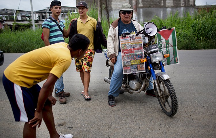 A vendor waits for customers while selling newspapers on his motorcycle, one week after an earthquake in Pedernales, Ecuador. A local journalist says years of self-censorship among the press led to 'timid' early reports of the disaster. (AP/Rodrigo Abd)