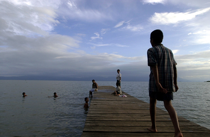 Niños juegan en el lago Izabal en Guatemala, en esta foto de agosto de 2002. La policía local arrestó el 11 de noviembre de 2017 a Jerson Antonio Xitumul Morales, un periodista del medio digital independiente Prensa Comunitaria, luego de que él informara sobre las protestas de un gremio de pescadores locales en la provincia de Izabal. (AP/Jaime Puebla)