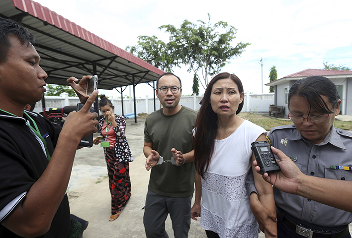 Singaporean journalist Lau Hon Meng, center left, and Malaysian journalist Mok Choy Lin, both accused for allegedly flying drones illegally over parliament buildings, are escorted during their trial at a court Friday, Nov. 10, 2017, in Naypyitaw, Myanmar. (AP/Aung Shine Oo)