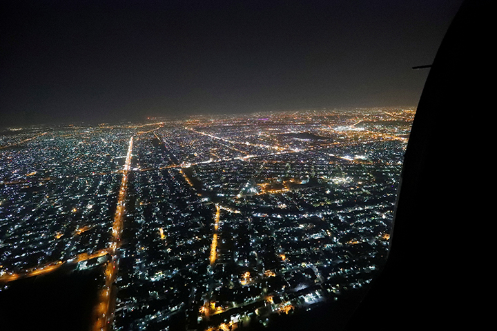 The city of Baghdad is seen out the door during a helicopter on October 23, 2017. Iraqi armed forces arrested freelance journalist and political commentator Samir Obeid a day after Obeid published an article that was critical of the country's prime minister. (Reuters/Pool/Alex Brandon)