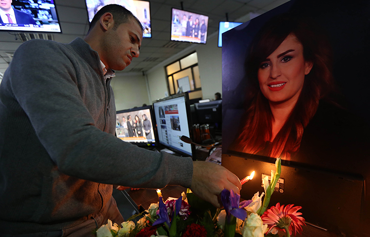 Um colega da repórter iraquiana Shifa Gardi acende uma vela em uma vigília para ela na redação da Rudaw TV em Erbil. O Iraque foi o país mais letal para jornalistas em 2017. (AFP / Safin Hamed)