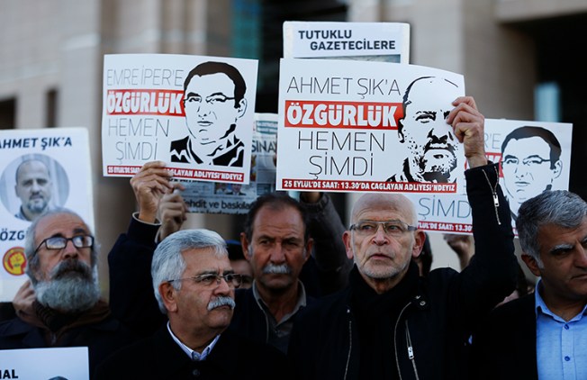 Jornalistas e manifestantes mantêm cartazes do lado de fora de um tribunal de Istambul em 31 de outubro de 2017, pedindo a libertação de colegas encarcerados, incluindo o repórter turco Ahmet Şık. A Turquia é o pior carcereiro de jornalistas de 2017. (AP / Lefteris Pitarakis)