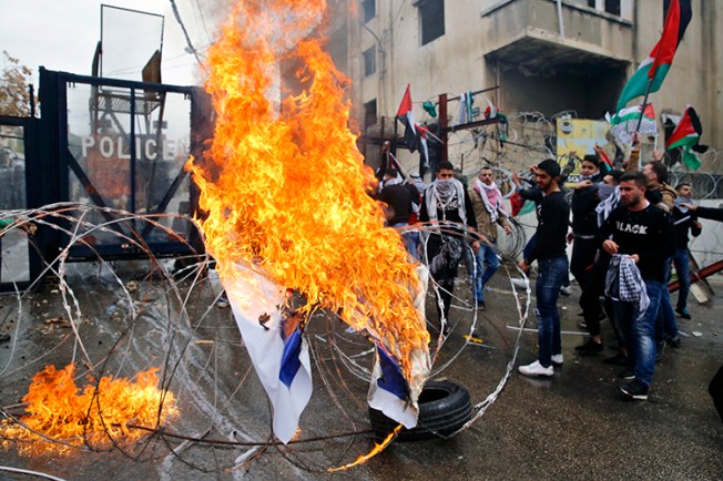 Protesters burn an Israeli flag in front of the U.S. Embassy in Lebanon, during a demonstration in Aukar, east of Beirut, on December 10. Rallies are being held in several countries after President Donald Trump said he will recognize Jerusalem as Israel's capital. (AP/Bilal Hussein)