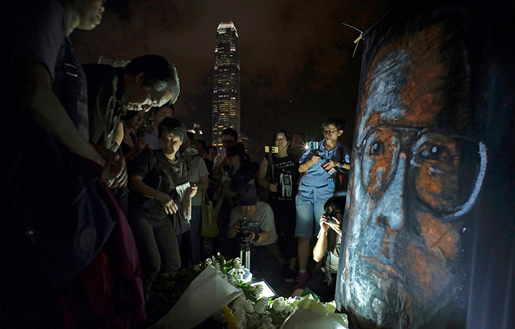 People pay tribute to Nobel laureate Liu Xiaobo in a park near Hong Kong's Victoria Habour in July 2017. The journalist died a few months after China finally agreed to release him on medical parole. (AP/Vincent Yu)