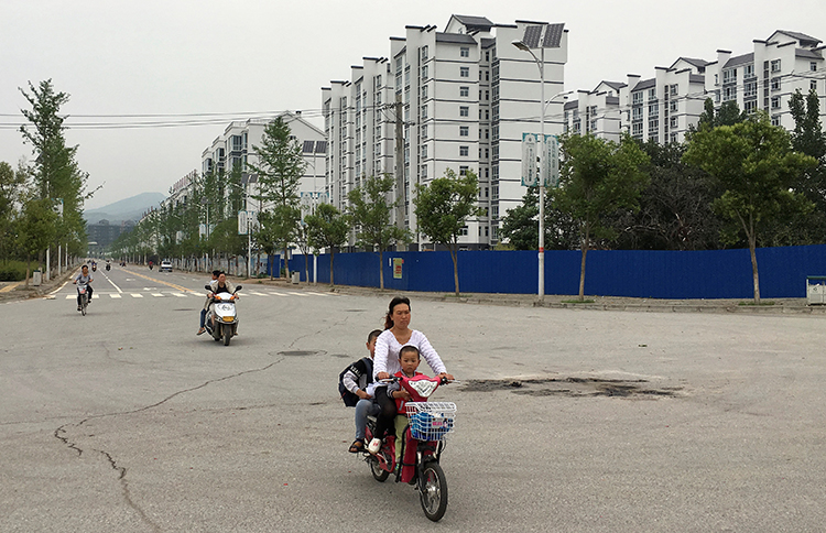 Residents ride electric scooters in a resettlement town in rural Shaanxi province. A journalist investigating a story at a hospital in the province says he was beaten by security guards. (Reuters/Sue-Lin Wong)
